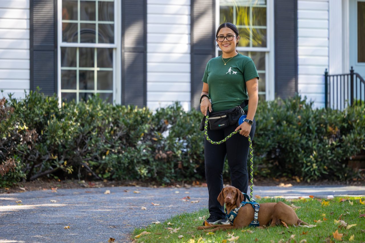 Professional dog walker with a happy dog on a neighborhood walk in Bethesda