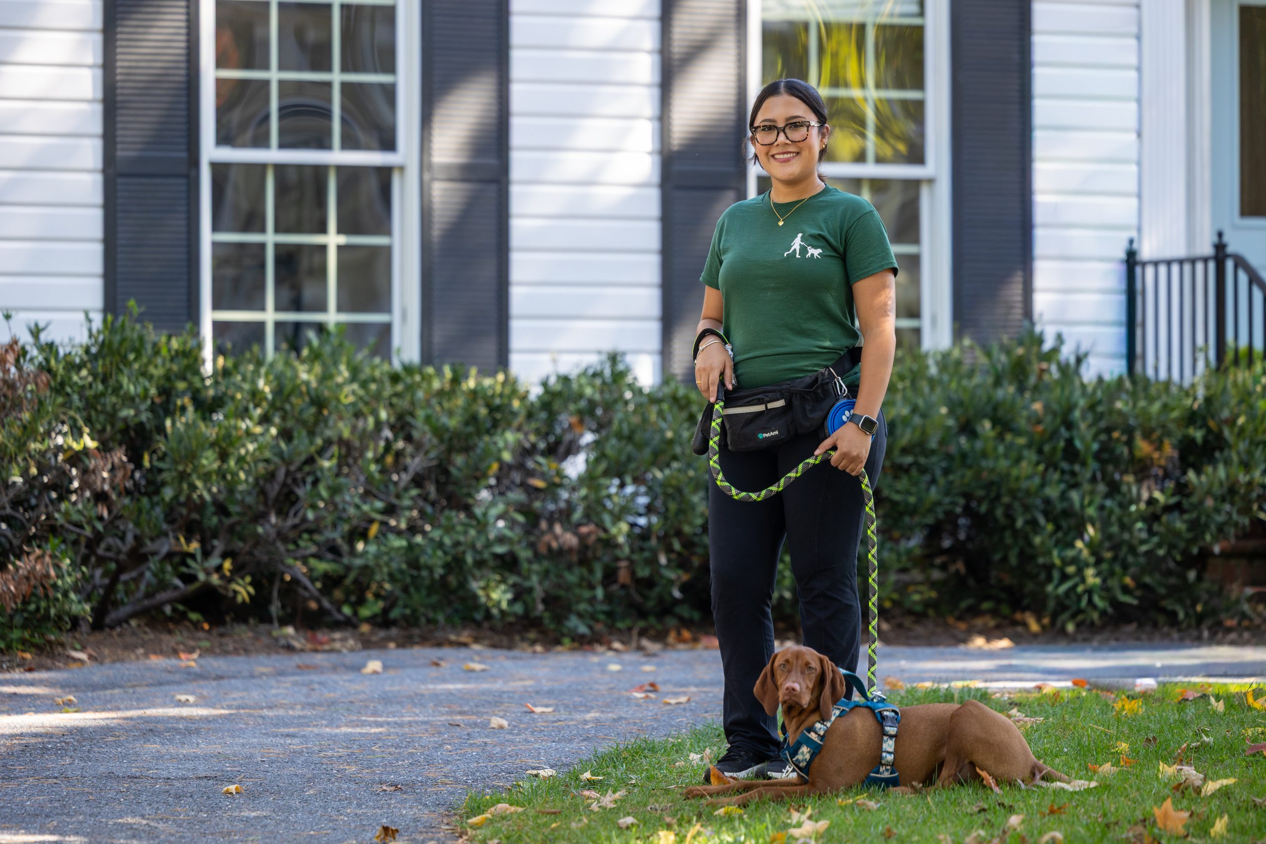 Professional dog walker with a happy dog on a neighborhood walk in Bethesda